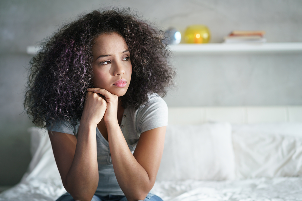 Depressed Hispanic woman, looking away with a sad expression