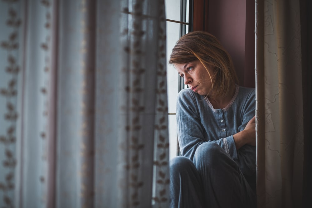 a woman sitting on a window sill